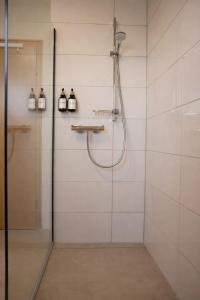 a shower with a glass door in a bathroom at Ferienwohnung Südwind 2 in Hohentengen +8 photos