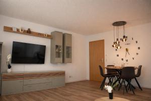 a living room with a television and a table with chairs at Ferienwohnung Südwind 2 in Hohentengen