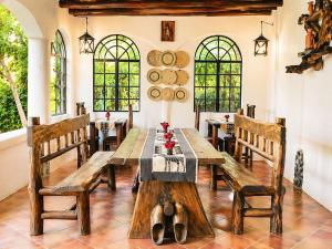 a dining room with a wooden table and benches at Kitunduni Lodge in Arusha