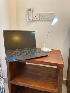a laptop computer sitting on top of a wooden table at LA PRINCE HOTEL and HOSTEL in Trincomalee