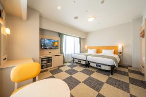 a hotel room with two beds and a tv at Hotel Monterey La Soeur Naha in Naha +68 photos