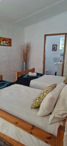 a bedroom with two beds and a mirror at White lily in Montagu