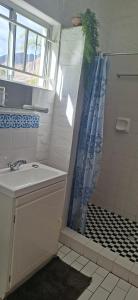 a bathroom with a shower curtain and a sink at White lily in Montagu +15 photos