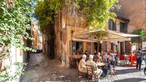 een groep mensen die in een openluchtrestaurant zitten bij Rental in Rome - Scala Suite in Rome