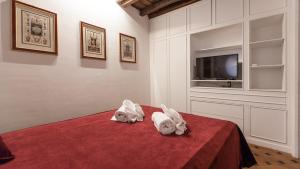 una camera con un letto rosso e due asciugamani di Rental in Rome - Scala Suite a Roma