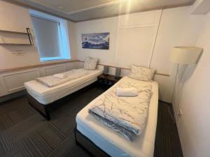 two beds in a small room with a window at Work & Stay KemptenCityHost in Kempten
