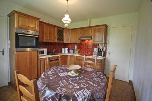 a kitchen with a table and chairs and a kitchen with wooden cabinets at Plaisance in Bujaleuf +20 photos