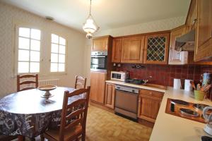 a kitchen with wooden cabinets and a table with a tableablish at Plaisance in Bujaleuf