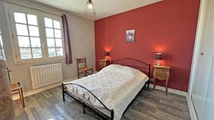 a bedroom with a bed and a red wall at Plaisance in Bujaleuf