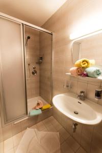 bagno con doccia, lavandino e specchio di "Quality Hosts Arlberg" Hotel-Gasthof Freisleben a Sankt Anton am Arlberg