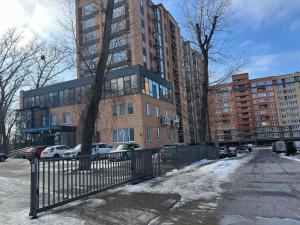 a tall brick building with cars parked in front of it at Квартира подобово класу "ЛЮКС" in Khmelnytskyi