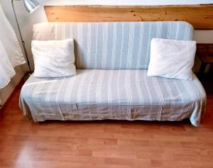a blue and white couch with two pillows on it at Apartmán Simi, Karlovice 251, 79323 Karlovice in Karlovice