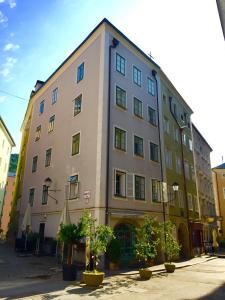 ザルツブルクにあるGuesthouse Mozart - Apartment Houseの目の前に木々が生い茂る大きな建物