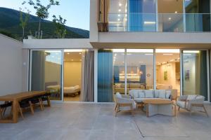 a house with a patio with a table and chairs at Luxury Pool Villa Palasea With Panoramic Sea View in Vlorë +36 photos