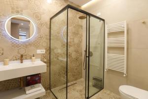 a bathroom with a shower and a sink and a toilet at Luxury Pool Villa Palasea With Panoramic Sea View in Vlorë