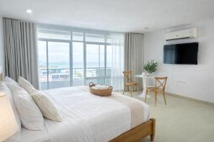 a bedroom with a large bed and a table with chairs at The Beach Bangsaen by Thanthita next to Wonnapa beach FREE DISNEY PLUS in Bangsaen