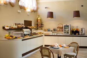 eine Küche mit einem Tisch und einer Theke mit Essen in der Unterkunft Hotel Spinelli in Viareggio