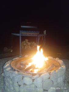 a fire pit in the sand at night at A Frame HAPPINESS in Yasinya