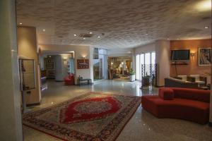 a large living room with a red couch and a rug at Hotel Meripol in Alba Adriatica