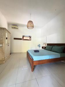 a bedroom with a bed and a pendant light at Black Sand hostel Amed in Amed
