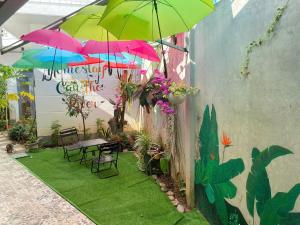 a patio with umbrellas and a table and chairs at Homestay canthoriver in Ấp Bình Lạc