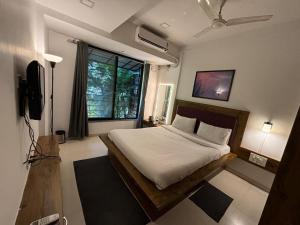 a bedroom with a bed and a large window at Sunleaf Palace in Pune