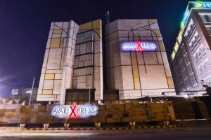 a large building with a sign on it at night at Avari Xpress Multan in Multan