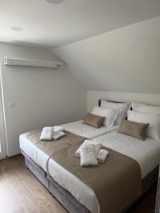 a bedroom with a large bed with towels on it at Apartments CRYSTAL AURA in Bohinj