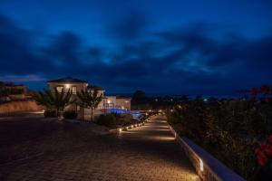 a house at night with lights on a sidewalk at Elafonisos Aqua Villa IV in Elafonisos