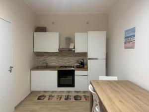 a kitchen with white cabinets and a table with shoes on the floor at Casa Vacanze Nicol in Licata
