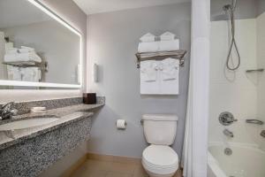 a bathroom with a toilet and a sink and a tub at Clarion Pointe in Winnipeg +38 photos
