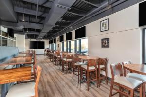 a dining room with wooden tables and chairs at Clarion Pointe in Winnipeg