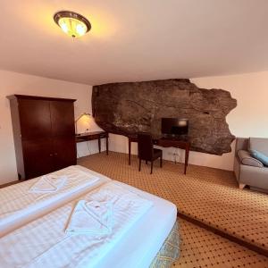 a hotel room with a bed and a rock wall at Penzion Kapr in Český Krumlov