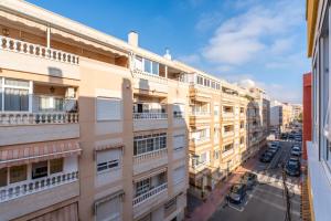 an apartment building with balconies on a city street at Zoa in Torrevieja