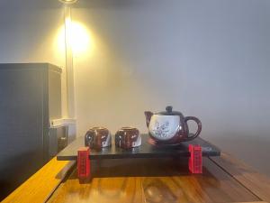 a tea pot and two tea cups on a table at Baisha Holiday Resort Lijiang in Lijiang