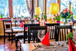 un restaurant avec des tables, des chaises et des serviettes rouges dans l'établissement Berg- und Aktivhotel Edelsberg GmbH, à Bad Hindelang
