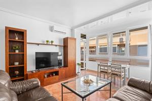 a living room with a couch and a television at Zoa in Torrevieja