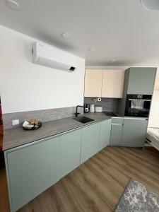 a kitchen with white cabinets and a counter top at Breeze Studio in Palanga