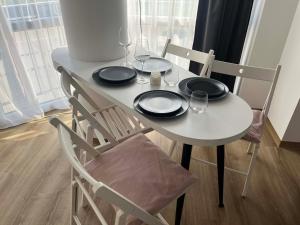 a table with two chairs and a white table with glasses at Breeze Studio in Palanga