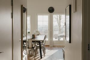a dining room with a table and chairs and a clock at Mösseberg Camping in Falköping