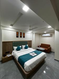 a bedroom with a large bed and a couch at Hotel Krishna Palace in Pālanpur