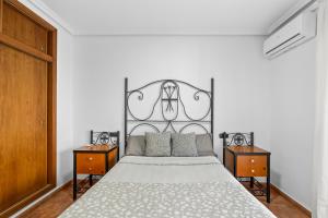 a bedroom with a large bed with a metal headboard at Zoa in Torrevieja