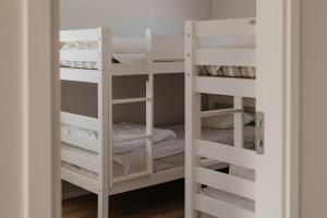 a bunk room with white bunk beds in it at Mösseberg Camping in Falköping