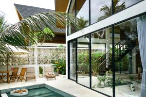 a house with a swimming pool and a patio at Dzen Greenfield Villa 6 in Ubud