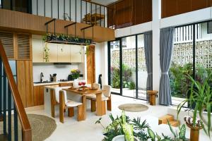 an open kitchen and dining room with a table and chairs at Dzen Greenfield Villa 6 in Ubud
