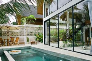 an external view of a house with a swimming pool at Dzen Greenfield Villa 6 in Ubud