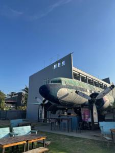 an airplane is parked in front of a building at Charlie's Hangar Surf Hostel in San Juan