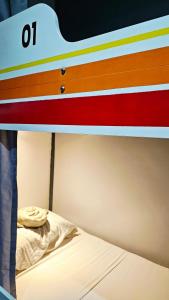 a bunk bed with colorful stripes on top of it at Charlie's Hangar Surf Hostel in San Juan +6 photos