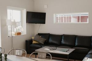 a living room with a black couch and a table at Mösseberg Camping in Falköping