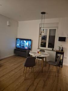 a living room with a table and a tv at Gala Lenassi in Kamnik